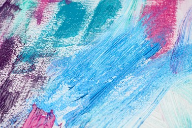 Photo of Strokes of colorful acrylic paints on white canvas, closeup