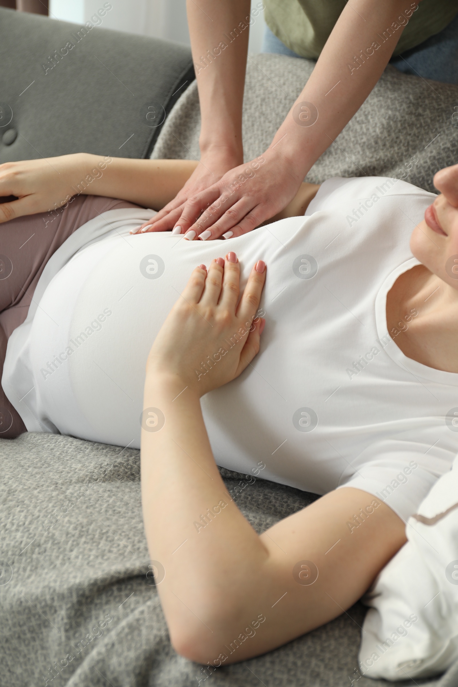 Photo of Doula taking care of pregnant woman at home, closeup. Preparation for child birth