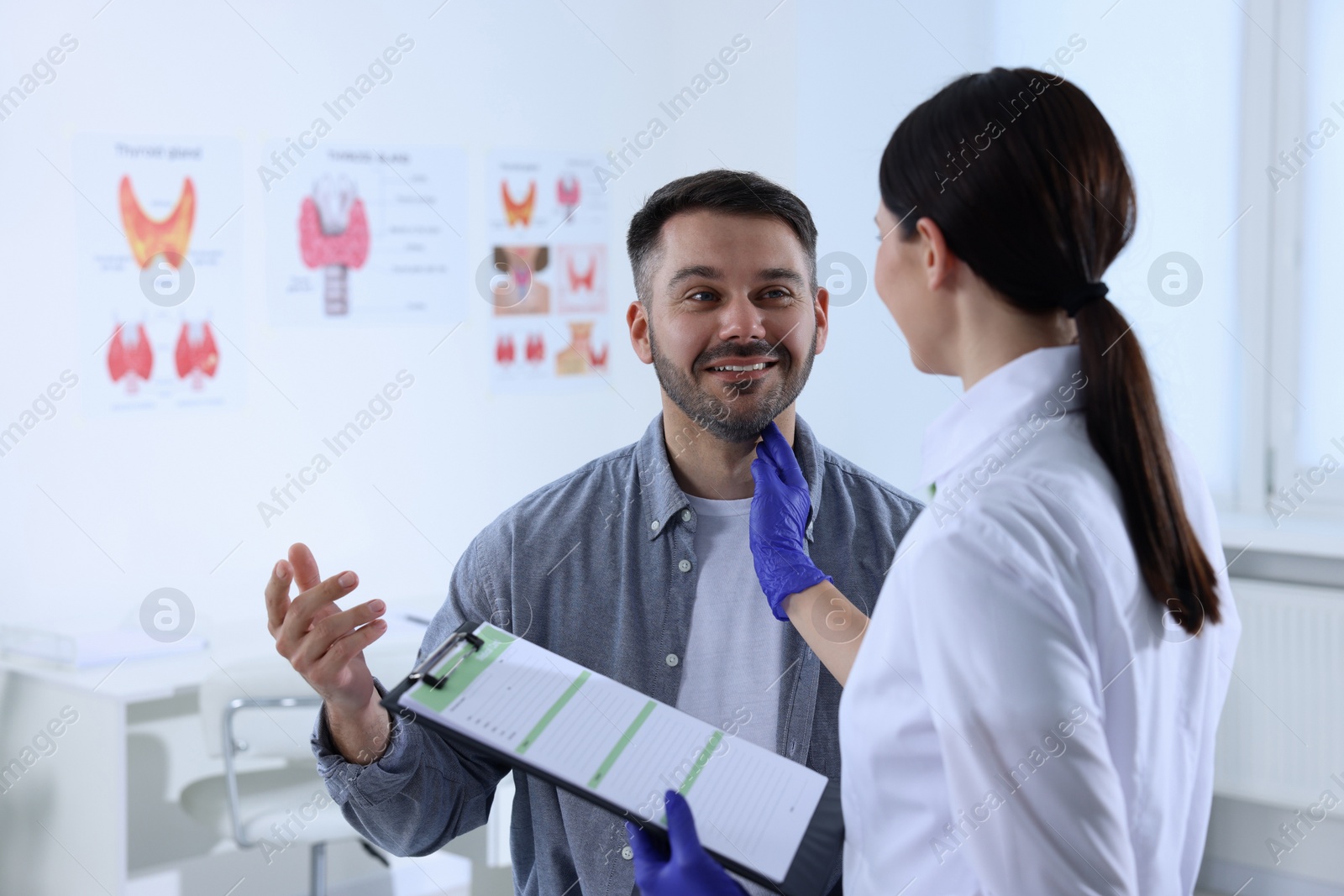 Photo of Endocrinologist examining thyroid gland of patient at hospital