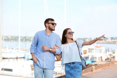 Photo of Young hipster couple in jean clothes on pier