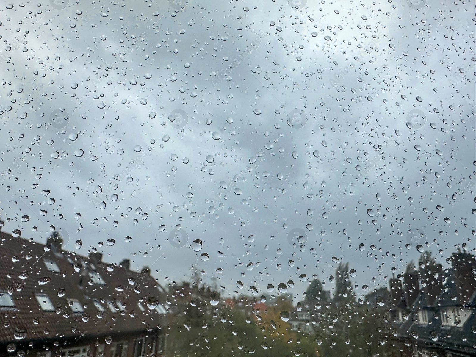 Photo of Window with water droplets on rainy day, closeup