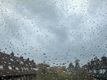 Window with water droplets on rainy day, closeup