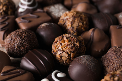 Photo of Different delicious chocolate candies as background, closeup