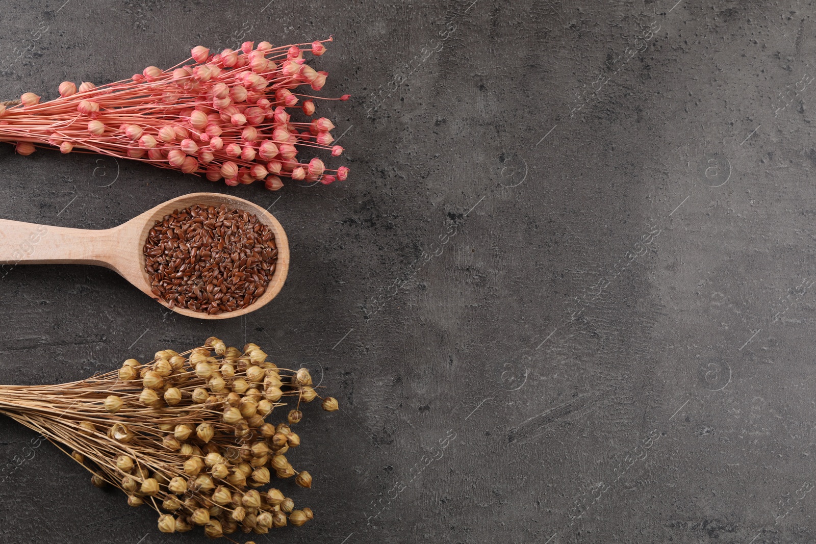 Photo of Dry flax plants and seeds on grey table, flat lay. Space for text