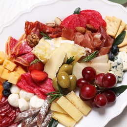 Photo of Plate full of tasty assorted appetizers, closeup