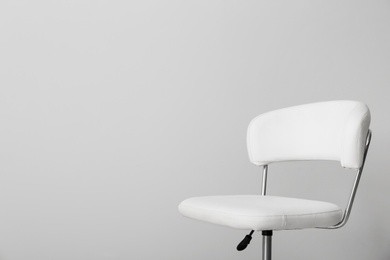 Photo of Comfortable office chair on light background. Space for text