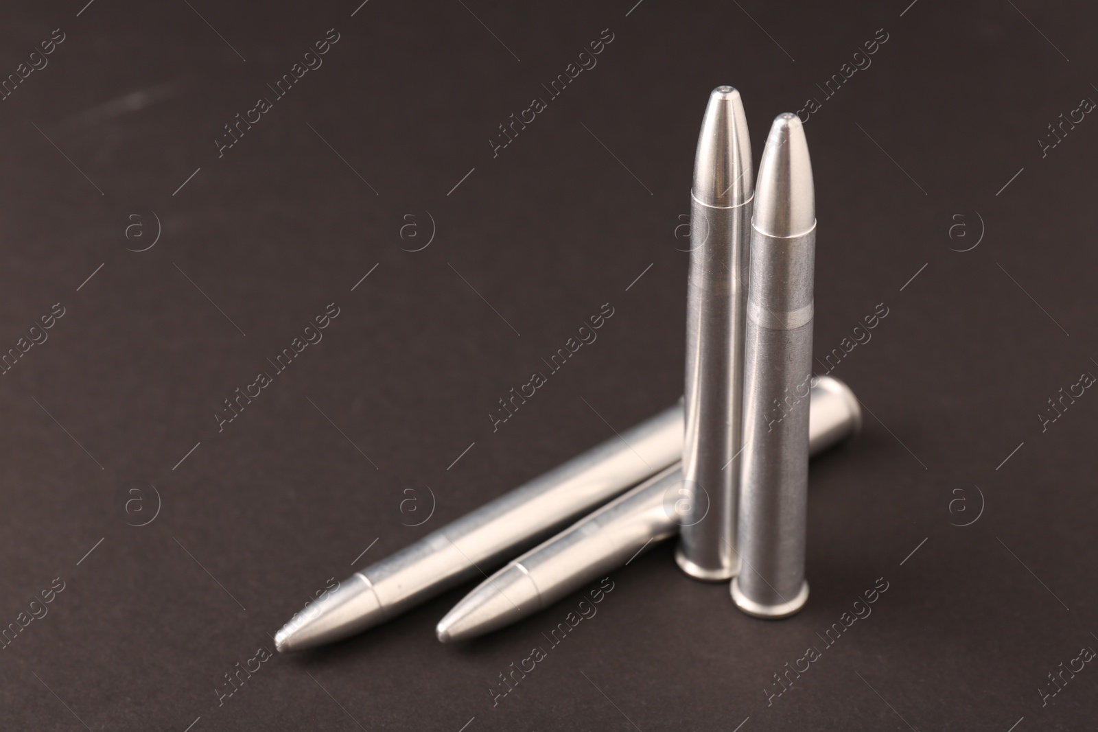 Photo of Many metal bullets on black background, space for text