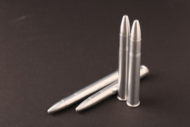 Photo of Many metal bullets on black background, space for text