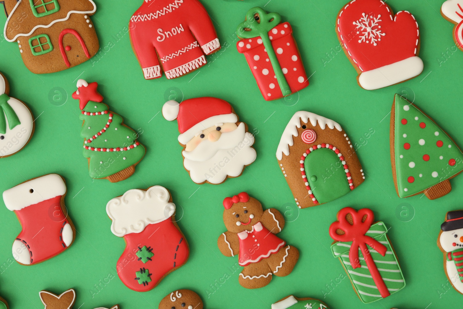 Photo of Different Christmas gingerbread cookies on green background, flat lay