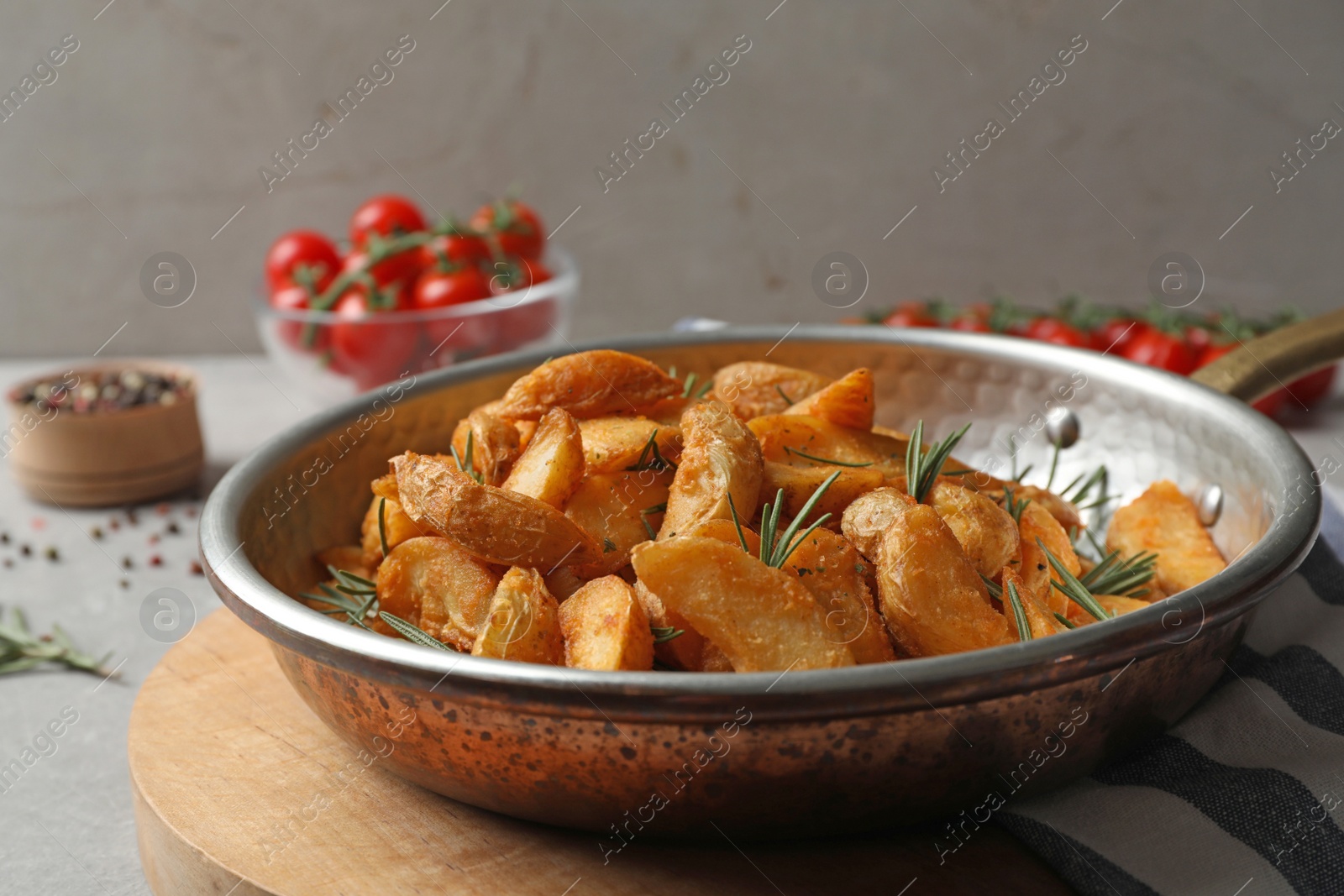 Photo of Baked potatoes with rosemary in frying pan on table