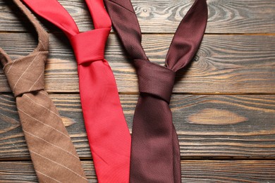 Photo of Different neckties on wooden table, flat lay. Space for text