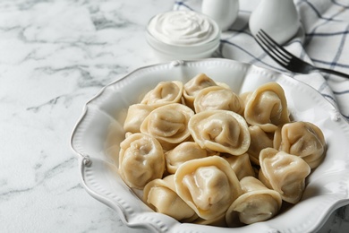 Photo of Portion of tasty dumplings on marble table