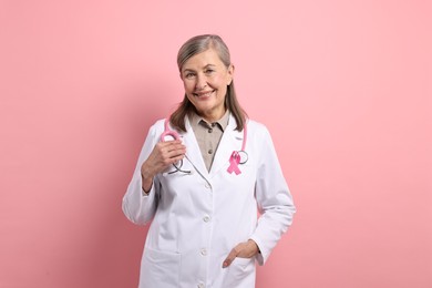 Photo of Mammologist with pink ribbon on color background. Breast cancer awareness