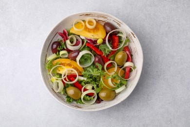 Photo of Bowl of tasty salad with leek and olives on light table, top view