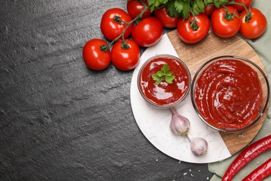 Photo of Organic ketchup in bowls and ingredients on black table, flat lay with space for text. Tomato sauce