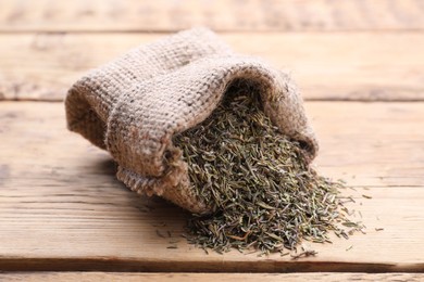Sack with dried thyme on wooden table, closeup