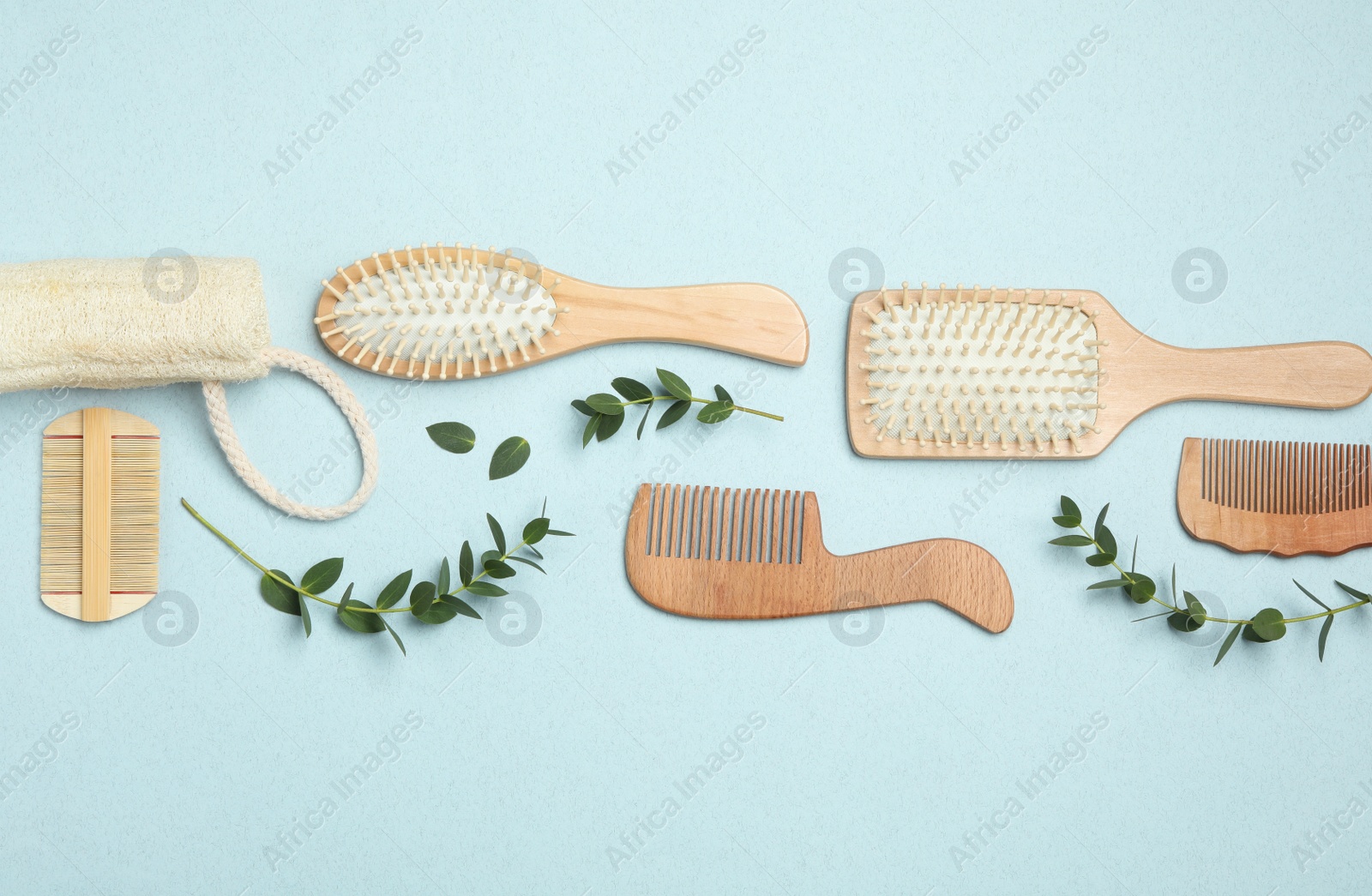 Photo of Flat lay composition with modern hair combs and brushes on light background