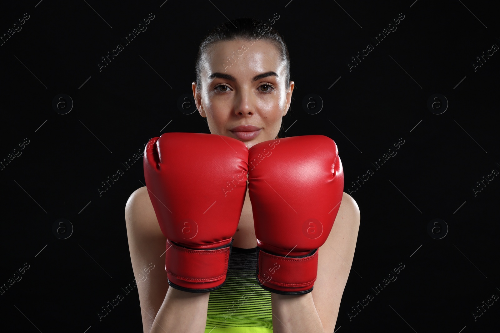 Photo of Portrait of beautiful woman in boxing gloves on black background