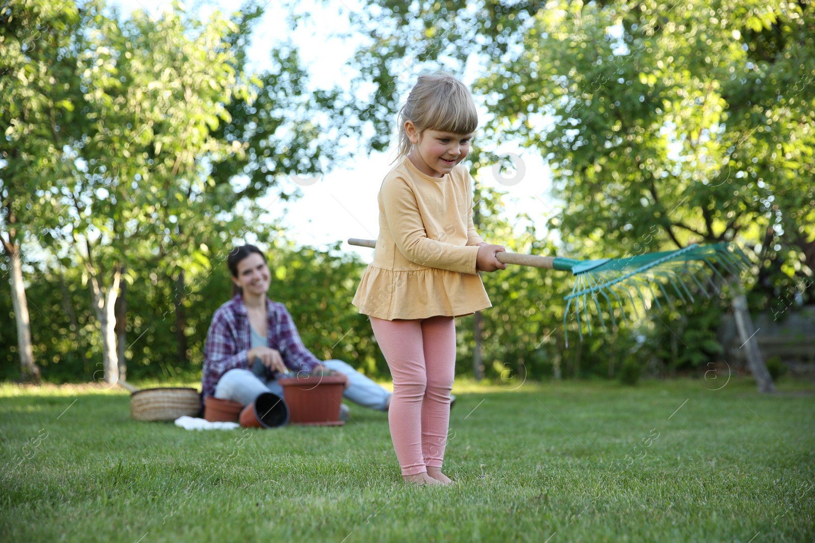 Photo of Mother and her daughter working together in garden