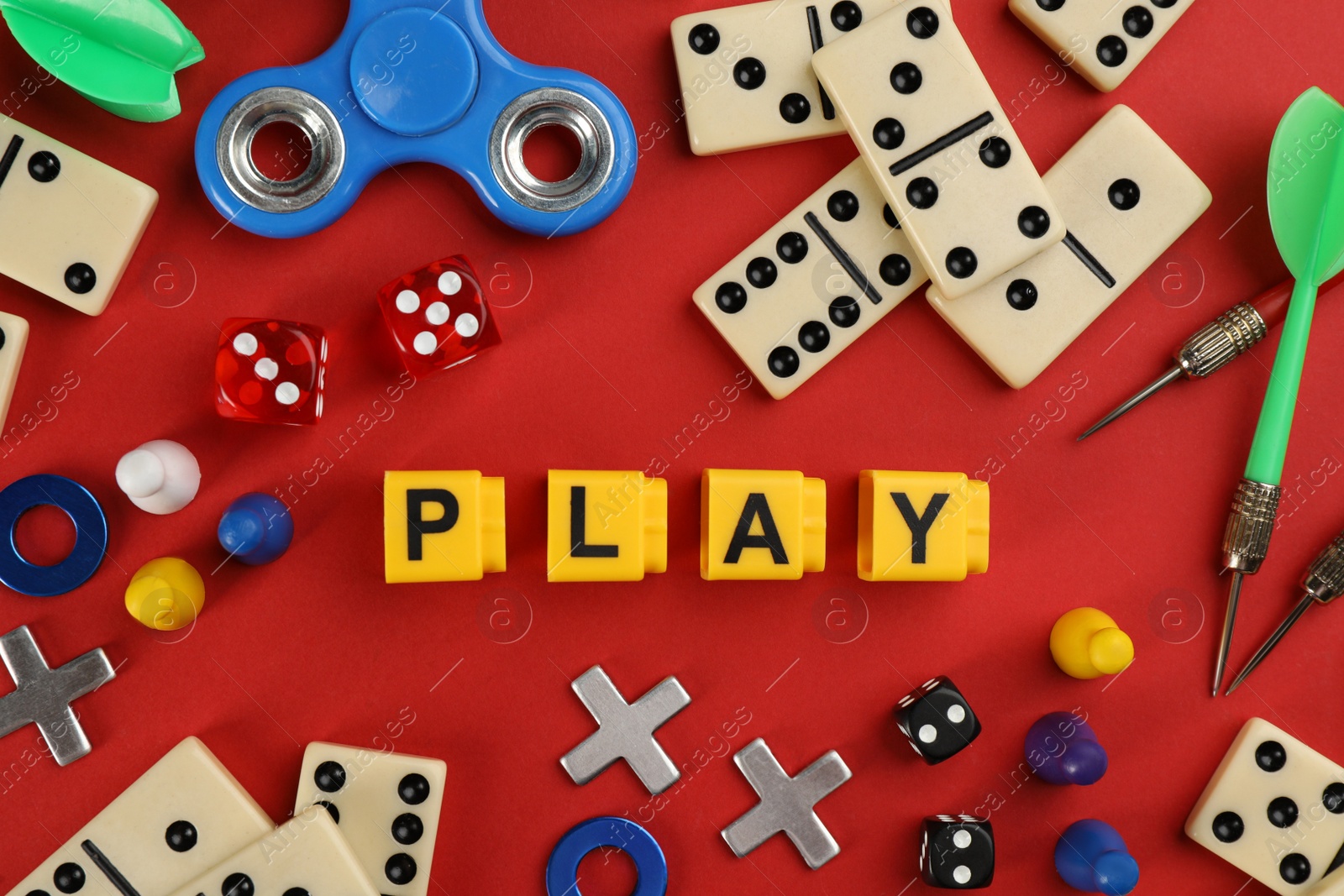 Photo of Components of board games and blocks with word Play on red background, flat lay