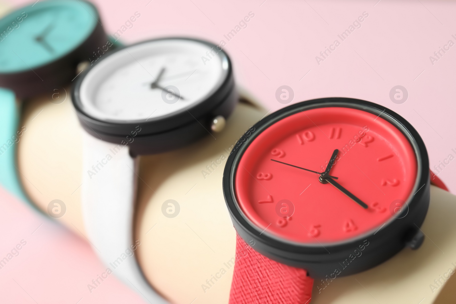 Photo of Holder with collection of stylish wrist watches on color background. Fashion accessory