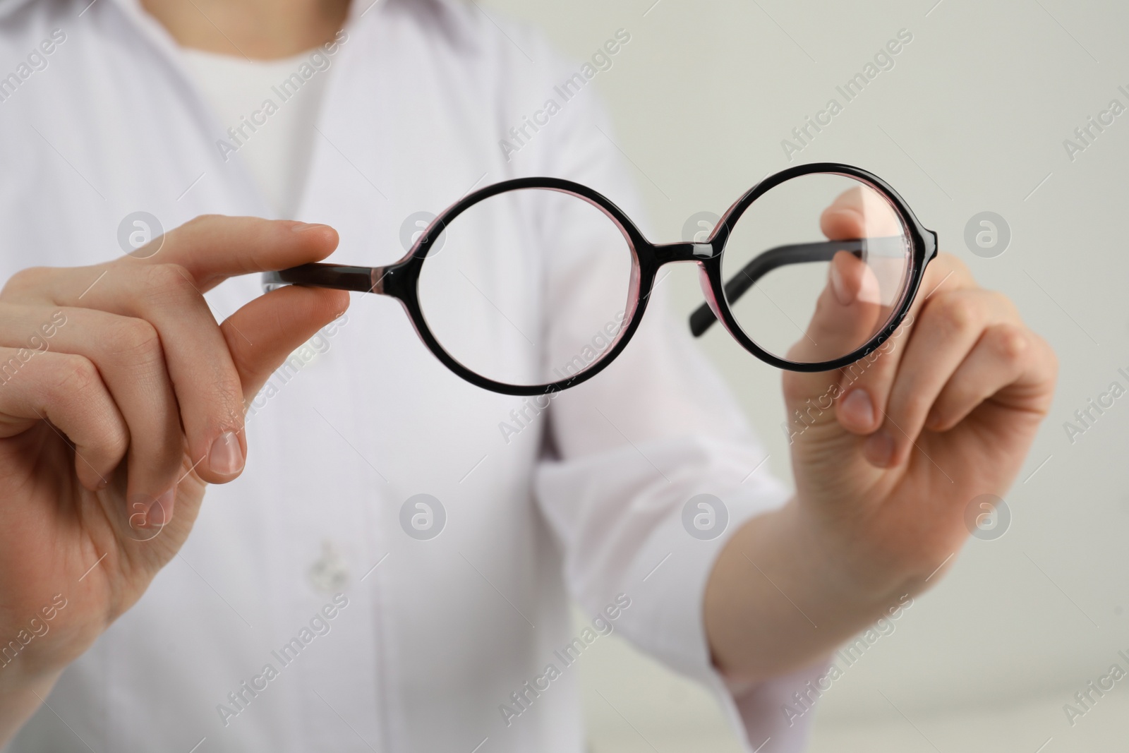 Photo of Woman with glasses on light background, closeup