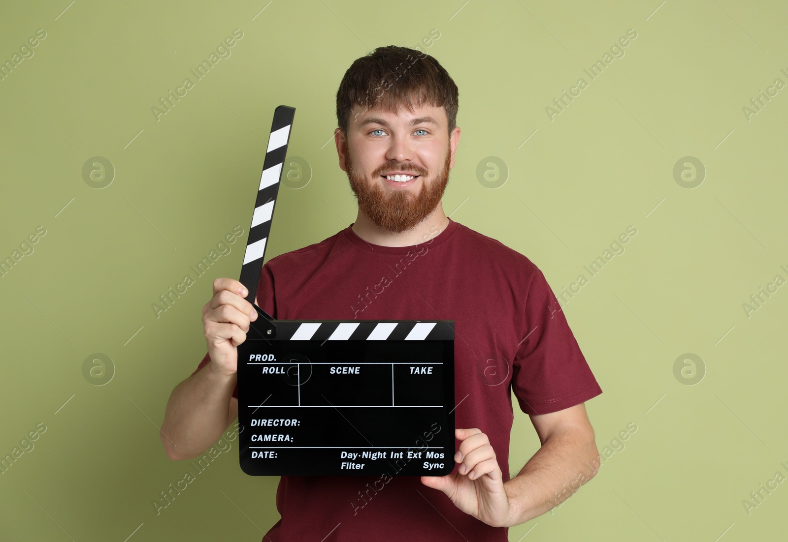 Photo of Making movie. Smiling man with clapperboard on green background