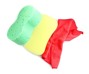 Sponges and car wash cloth on white background, top view