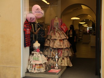 JESI, ITALY - MAY 17, 2022: Beautiful dresses made of newspapers in boutique, view from outside