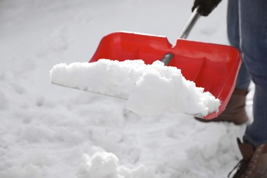 Photo of Person shoveling snow outdoors on winter day, closeup