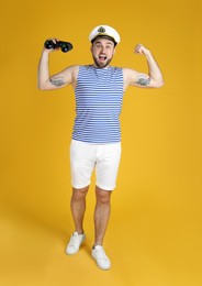 Photo of Emotional sailor with binoculars on yellow background