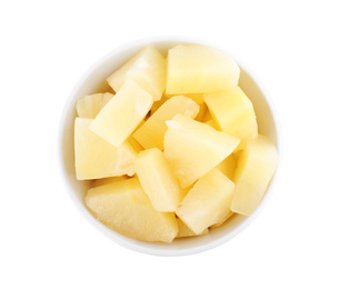 Pieces of delicious canned pineapple in bowl on white background, top view