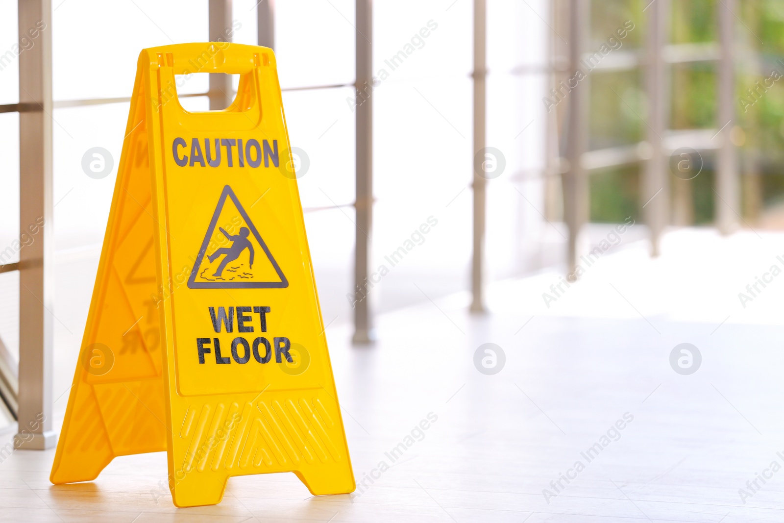 Photo of Safety sign with phrase Caution wet floor, indoors. Cleaning service