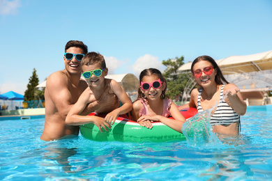 Photo of Happy family in swimming pool. Summer vacation