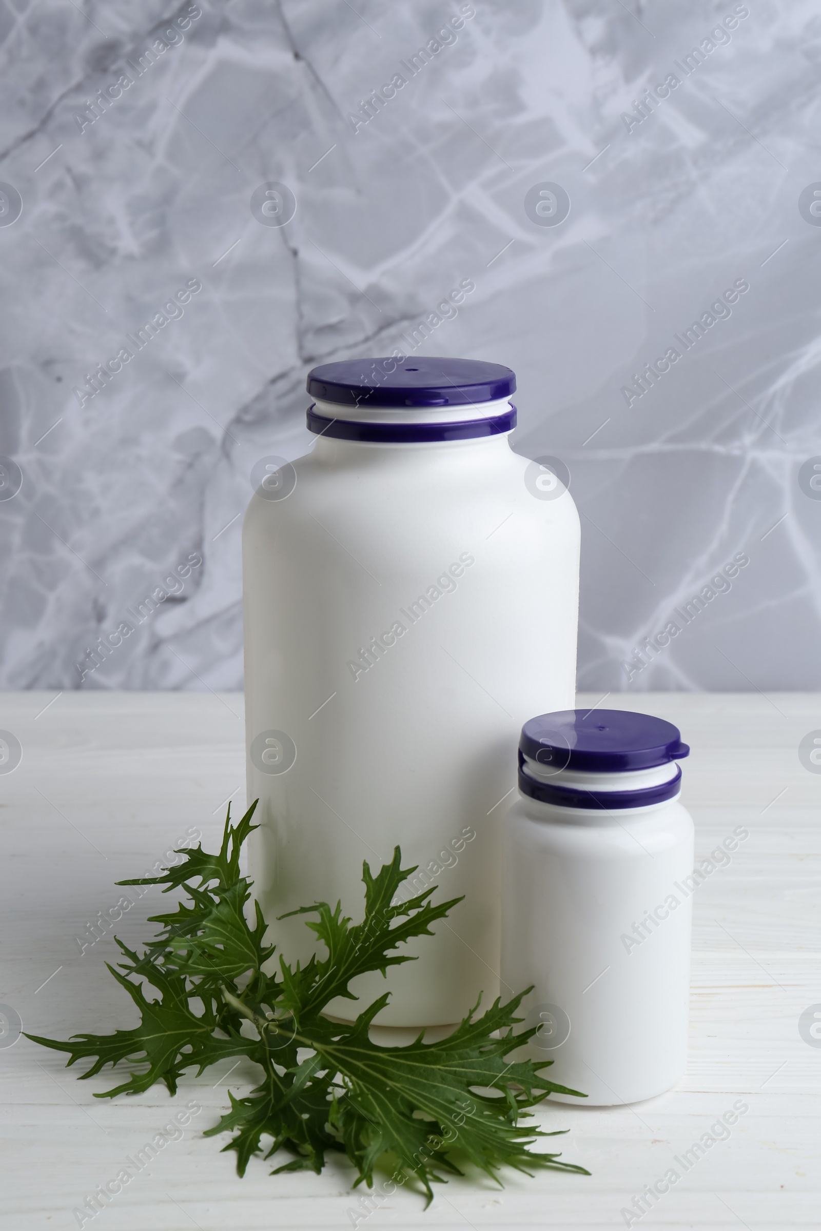 Photo of Medical bottles and arugula on white wooden table