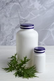 Photo of Medical bottles and arugula on white wooden table