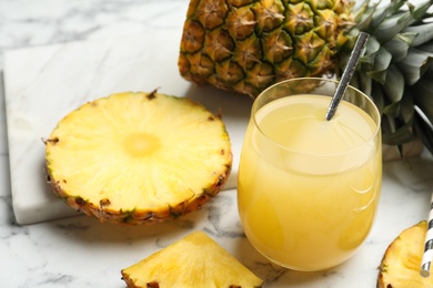 Delicious pineapple juice and fresh fruit on white marble table