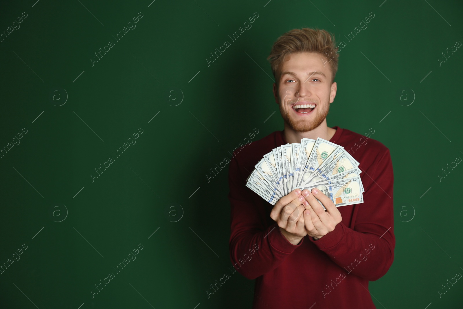 Photo of Young man with money on color background. Space for text