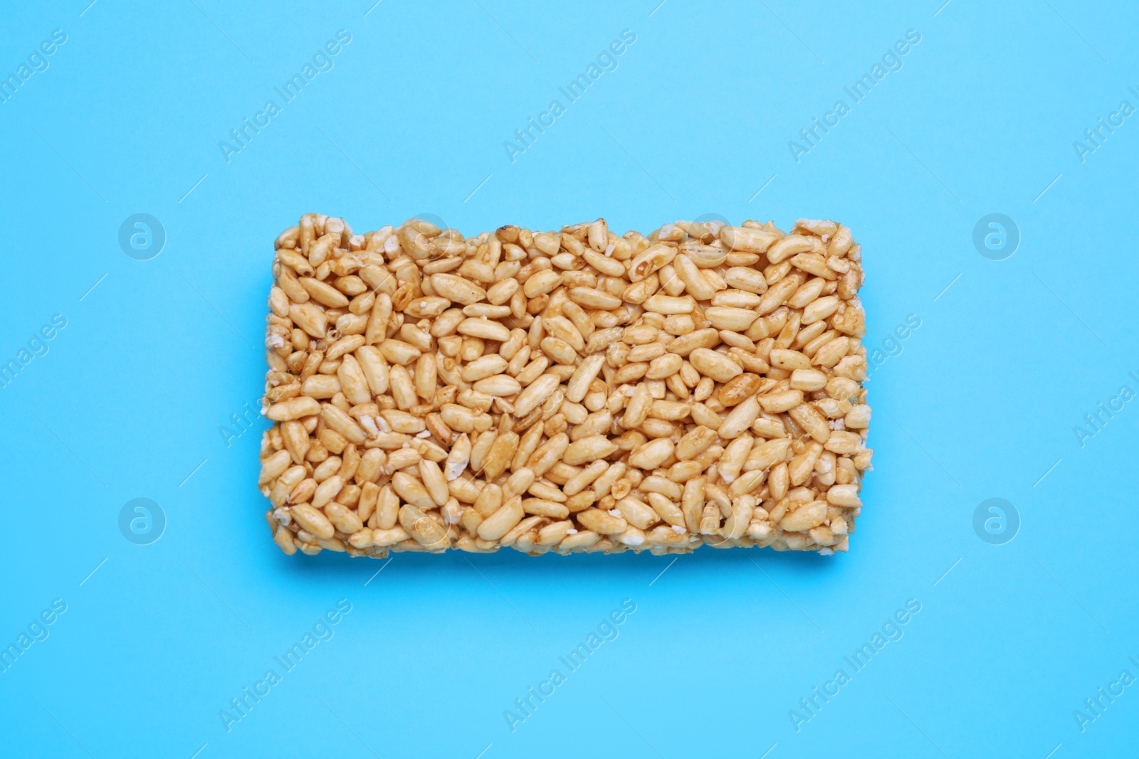 Photo of Puffed rice bar (kozinaki) on light blue background, top view