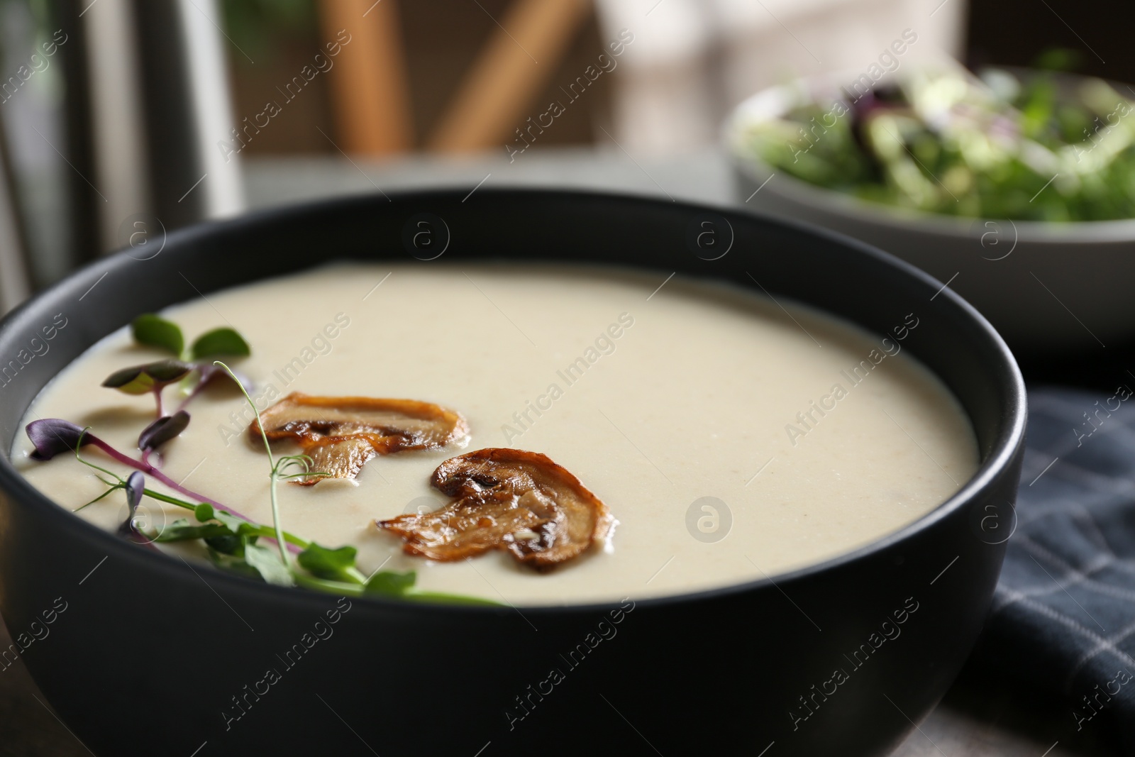 Photo of Delicious cream soup with mushrooms in bowl, closeup