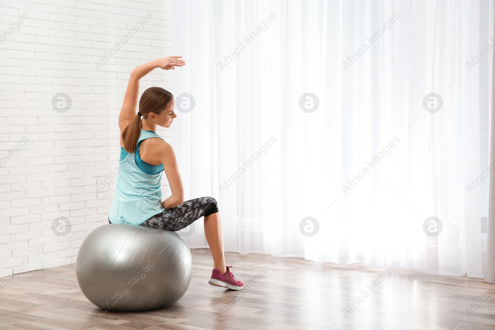 Photo of Young woman doing fitness exercises at home. Space for text