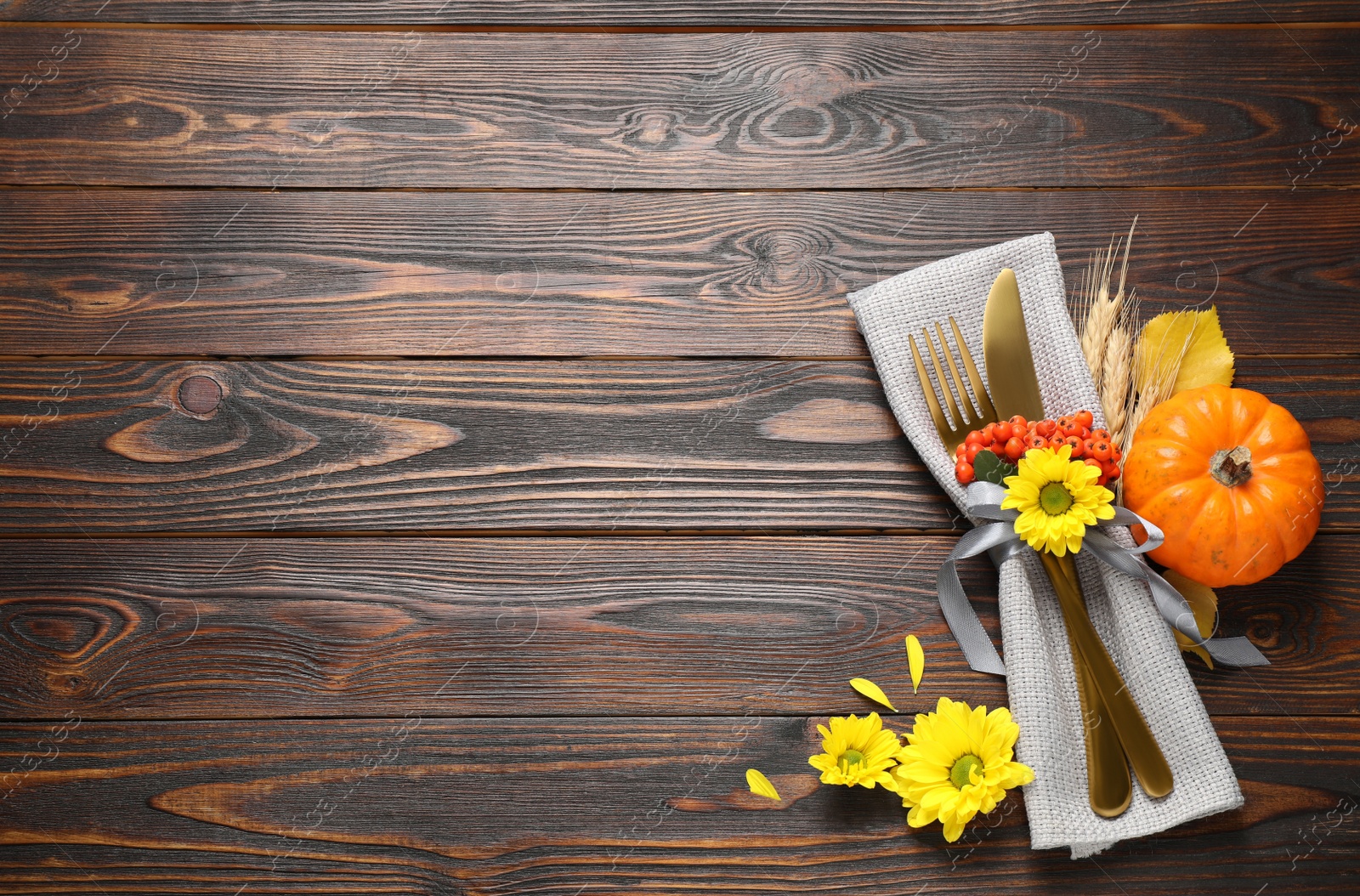 Photo of Cutlery and autumn decor on wooden table, flat lay with space for text. Thanksgiving Day celebration