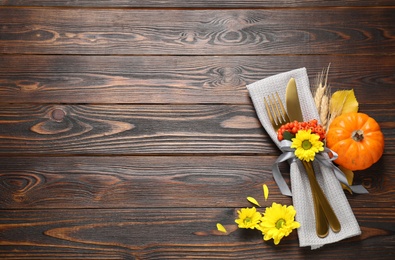 Cutlery and autumn decor on wooden table, flat lay with space for text. Thanksgiving Day celebration