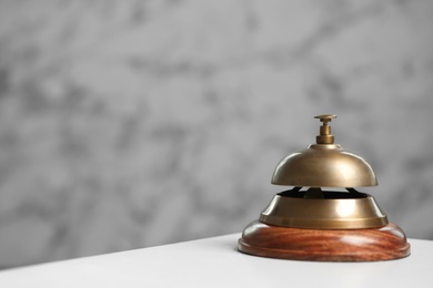 Photo of Hotel service bell on white table. Space for text