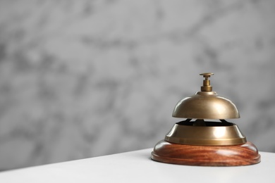 Hotel service bell on white table. Space for text