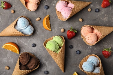 Photo of Flat lay composition with delicious ice creams in waffle cones on table