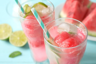 Photo of Glasses of refreshing watermelon drink on blue table, closeup