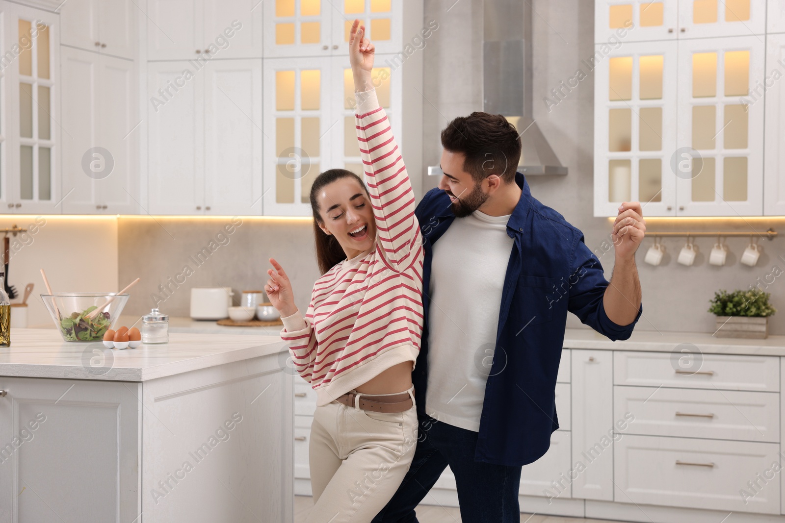 Photo of Happy lovely couple dancing together in kitchen