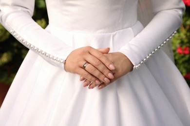 Photo of Bride wearing beautiful engagement ring and wedding dress, closeup