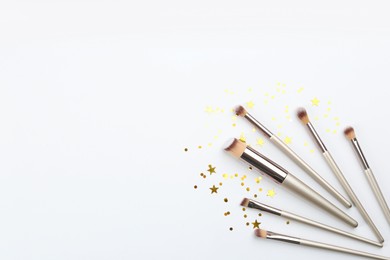 Photo of Flat lay composition with makeup brushes on white background, space for text